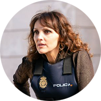 Ines Villegos has shoulder-length, wavy, brown hair and is wearing a brown sweater